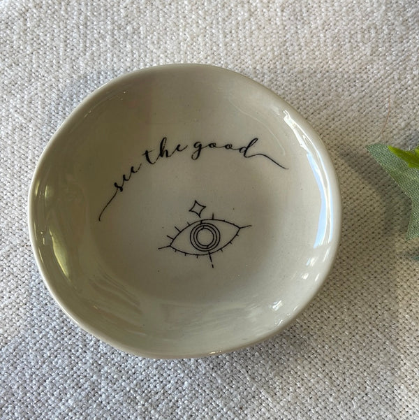 Small ceramic dish with eye image that has the words “see the good” 