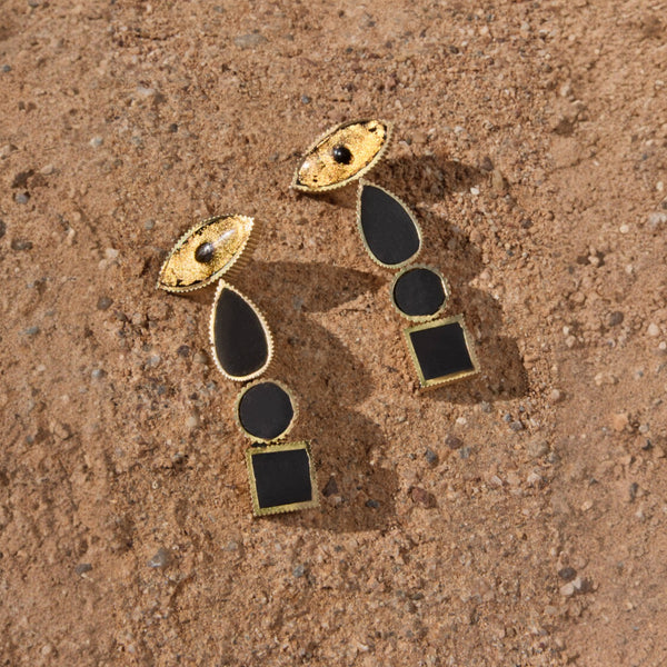 a modern take on the mati Earrings.  Long and elegant.   gold almond shaped eye on the top with 3 black and gold shapes of teardrop, circle and square dropping down, A beatuiful statement pair of earrings. Hand made in Greece by Greek designer Nayak.